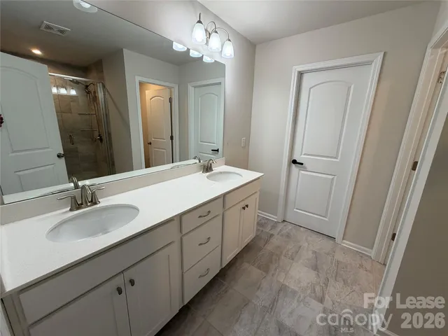 a spacious bathroom with a double vanity sink double and mirror