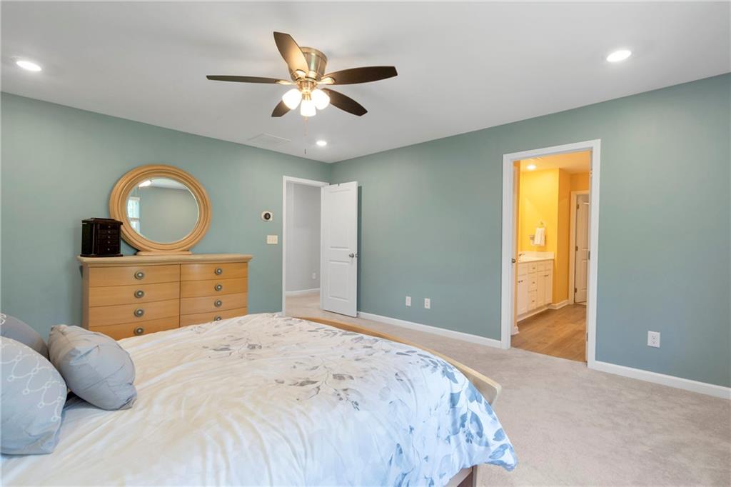 660 Groover Street Ball Ground, GA 30107 - Photo 25 of 53 a bedroom with a bed and a chandelier