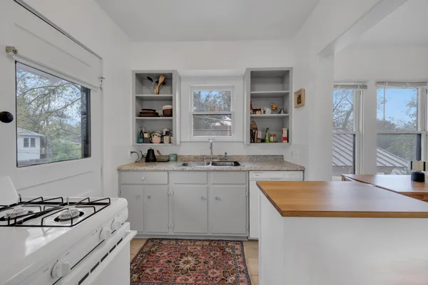 a kitchen with stainless steel appliances granite countertop a sink stove and cabinets