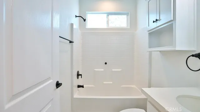 a bathroom with a granite countertop bathtub shower and sink