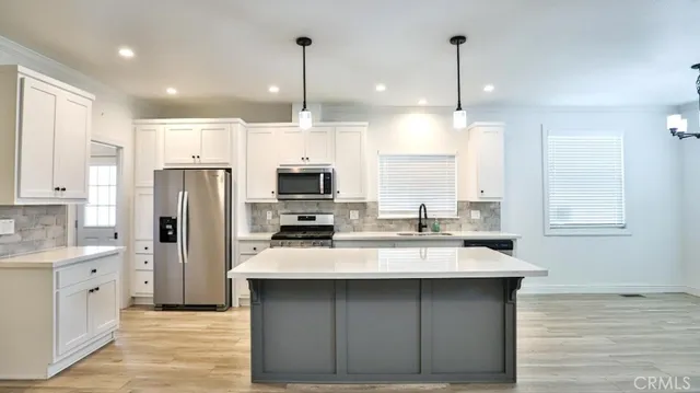 a kitchen with stainless steel appliances a sink a stove a refrigerator and cabinets