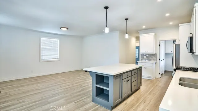 a kitchen that has a lot of cabinets and wooden floor