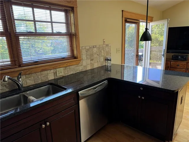 a kitchen with granite countertop stainless steel appliances and wooden cabinets