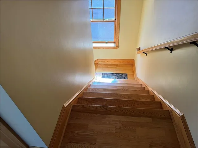 a view of a hallway with wooden floor and closet