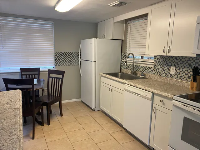 a kitchen with cabinets and a refrigerator