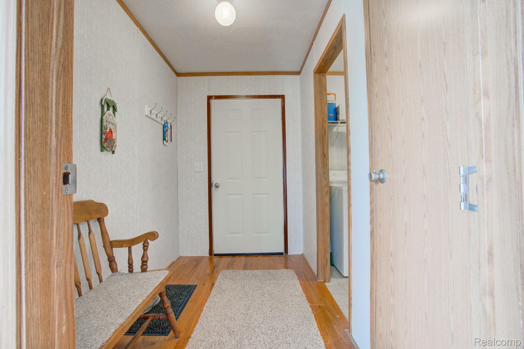12145 South Bancroft Road Morrice, MI 48857 - Photo 33 of 41 HALLWAY ENTRY OFF GARAGE AND LAUNDRY ROOM ON THE RIGHT