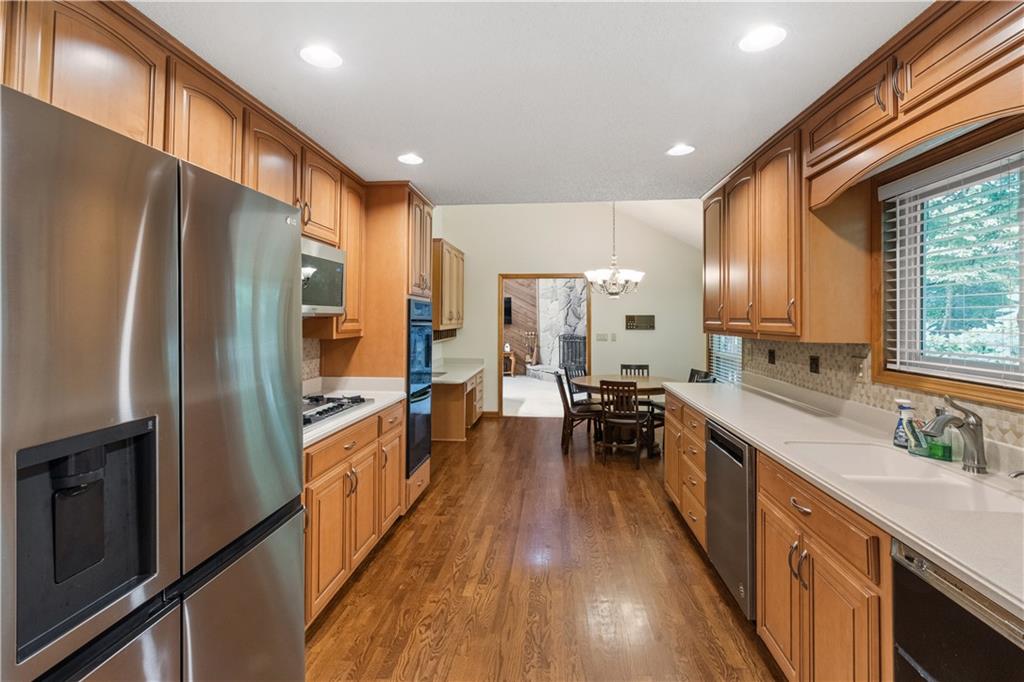 3711 Frey Lake Road Northwest Kennesaw, GA 30144 - Photo 12 of 37 a kitchen with stainless steel appliances a refrigerator a sink dishwasher a stove and white cabinets with wooden floor