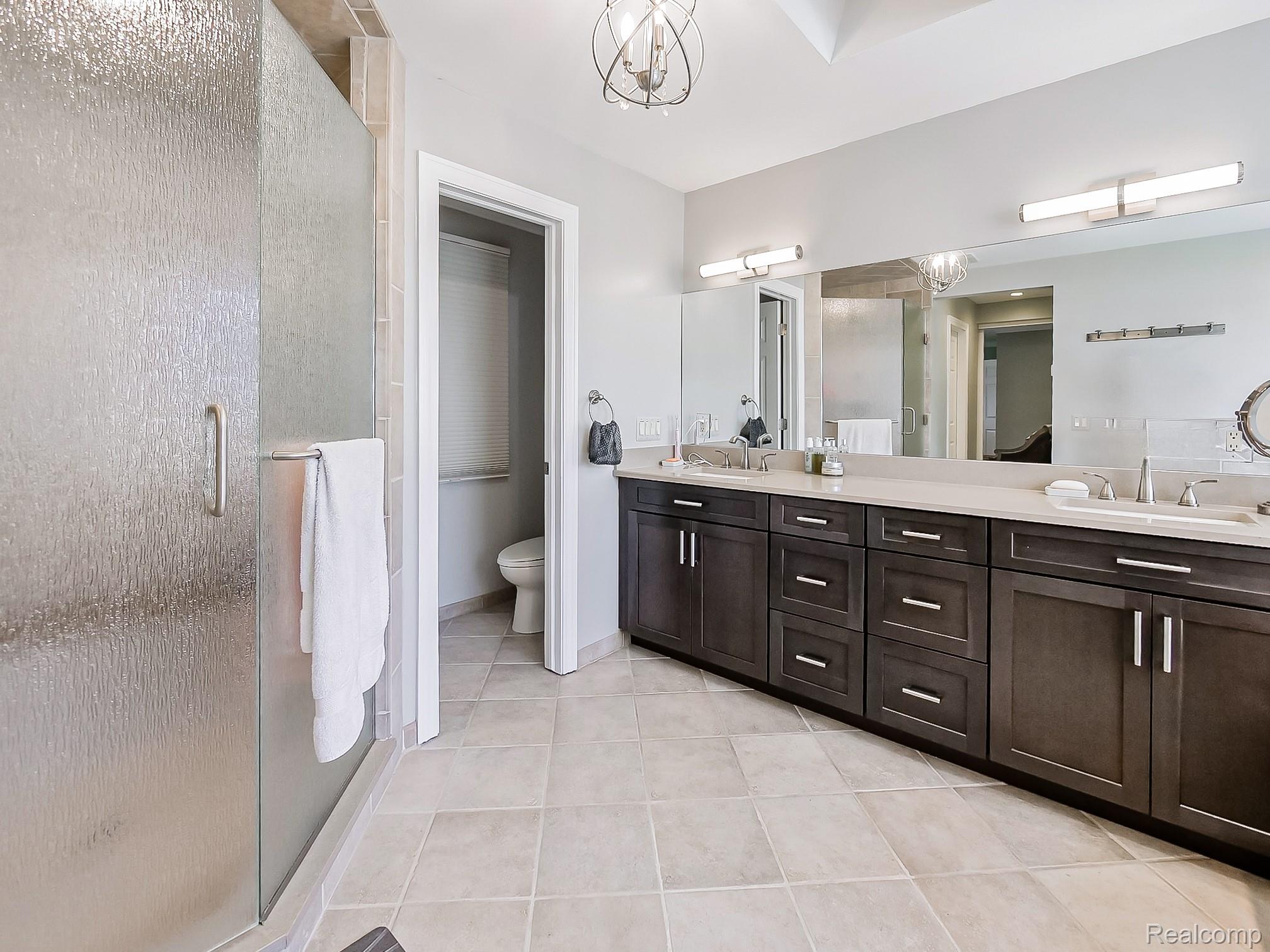 3720 East Clarkston Road Oakland, MI 48363 - Photo 22 of 60 Bathroom with double vanity, suspended lighting, a shower stall, and light tile patterned floors