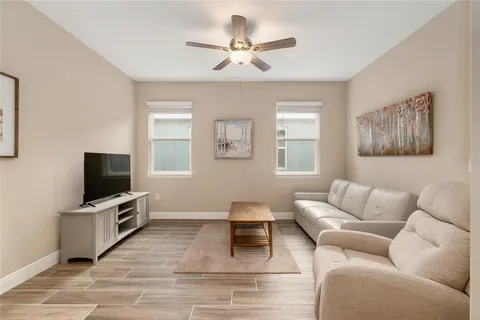 a large white kitchen with a large counter top appliances and wooden floor