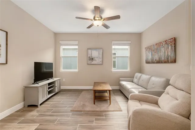 a large white kitchen with a large counter top appliances and wooden floor
