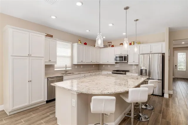 a kitchen with stainless steel appliances white cabinets and a stove top oven