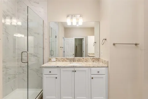a bathroom with a granite countertop sink toilet and a mirror