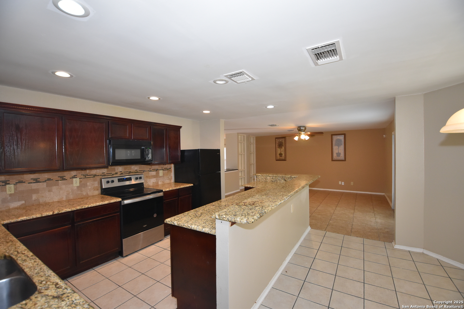 1607 Pinetum Drive San Antonio, TX 78213 - Photo 11 of 26 a kitchen with stainless steel appliances kitchen island granite countertop a refrigerator and a stove top oven