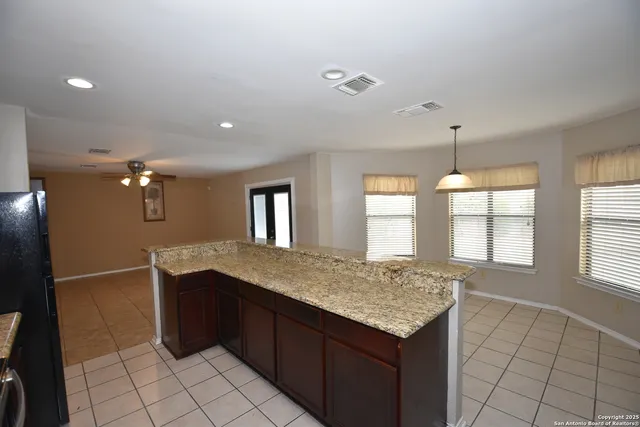 a kitchen with a granite countertop sink and cabinets