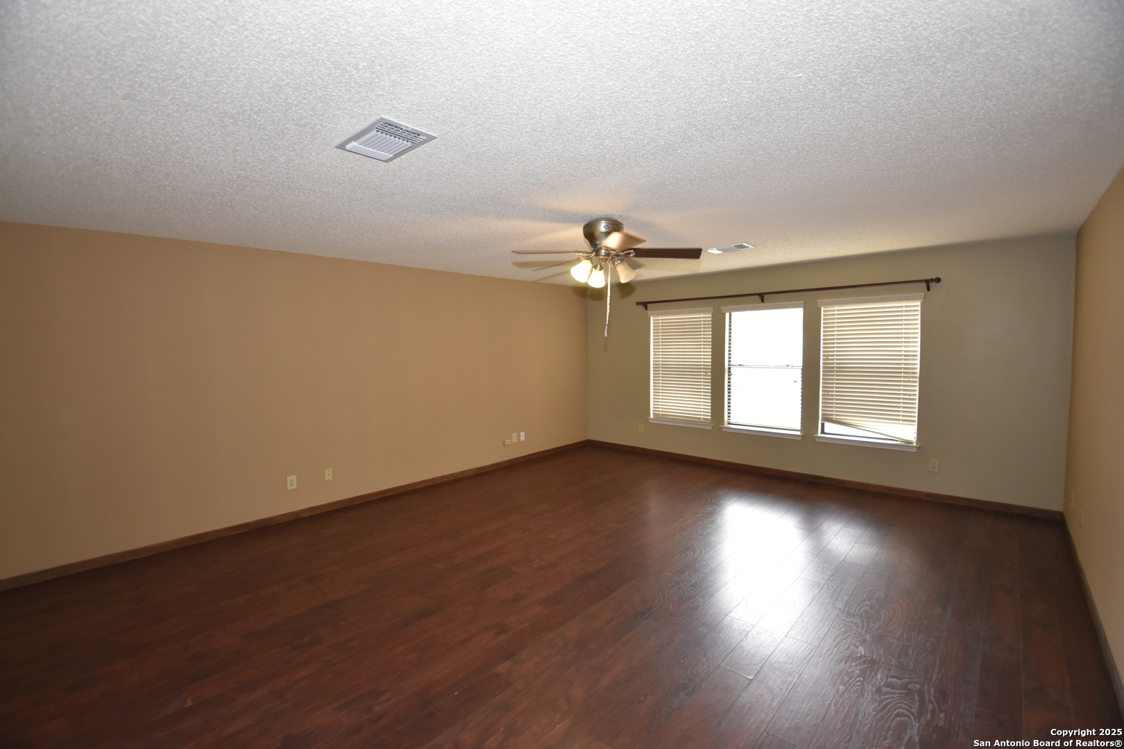 1607 Pinetum Drive San Antonio, TX 78213 - Photo 13 of 26 an empty room with wooden floor and windows