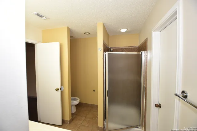 a bathroom with a shower and a glass door