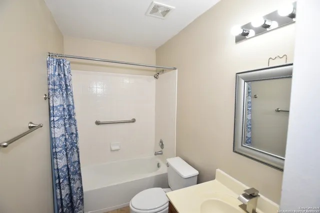 a bathroom with a shower a toilet and a sink