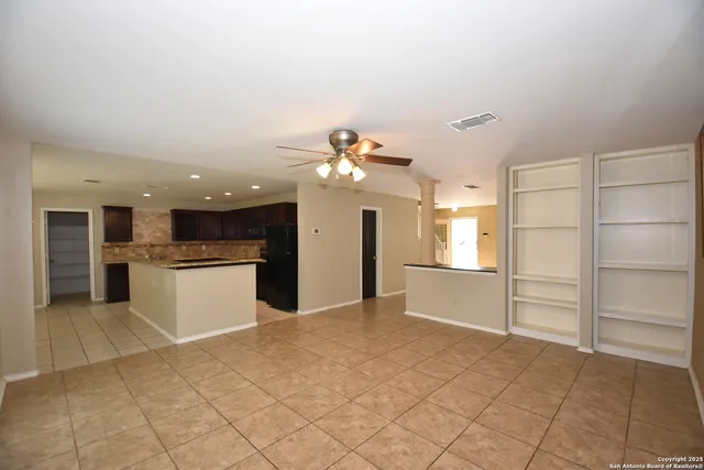 a kitchen with a refrigerator and white cabinets