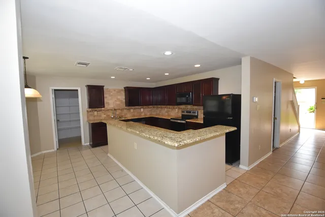 a kitchen with stainless steel appliances granite countertop a refrigerator and a stove