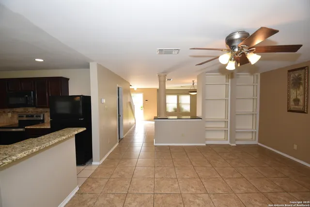 a kitchen with stainless steel appliances kitchen island granite countertop a refrigerator and a sink
