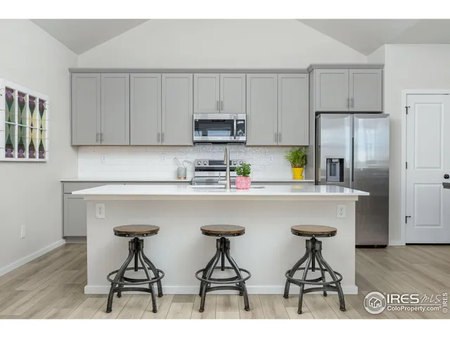 a kitchen with stainless steel appliances kitchen island granite countertop a sink a stove top oven a counter space and cabinets