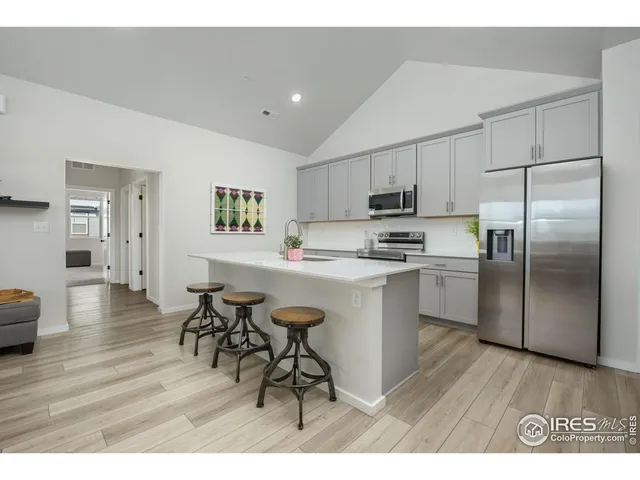 a kitchen with stainless steel appliances a sink cabinets and wooden floor