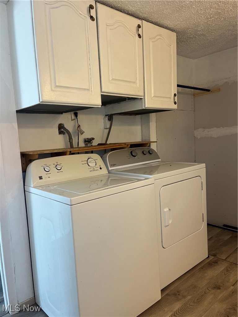 57894 Flamingo Road Senecaville, OH 43780 - Photo 13 of 20 Laundry area featuring cabinet space, a textured ceiling, independent washer and dryer, and wood finished floors