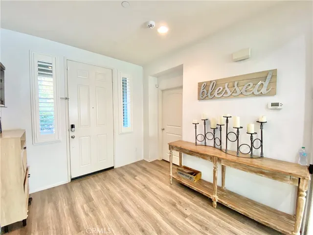a living room with furniture kitchen view and a wooden floor