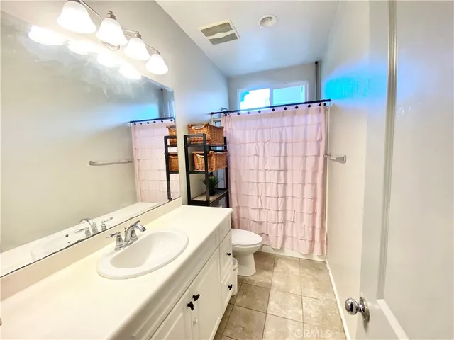 a kitchen with granite countertop white cabinets and refrigerator