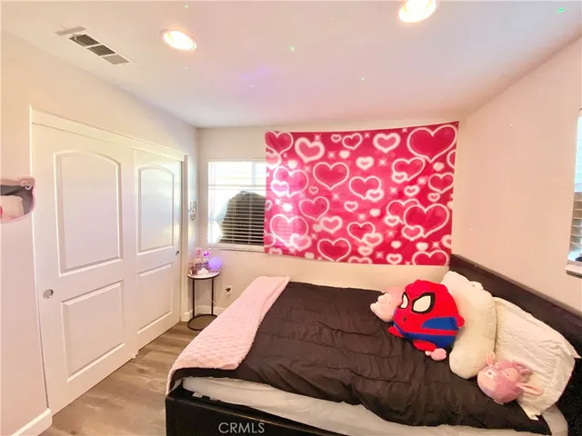 a bedroom with a bed and a flat tv screen on the dresser