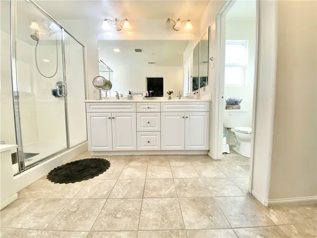 a spacious bathroom with a tub a double vanity sink and mirror