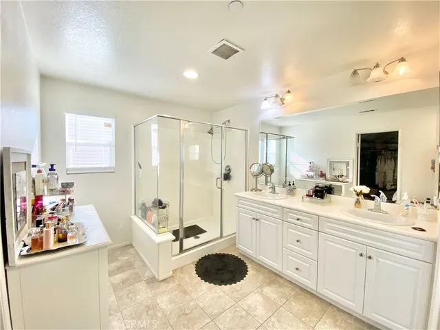 a bathroom with a double vanity sink a toilet and shower