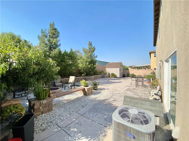 a view of a patio with couches and table and chairs and potted plants
