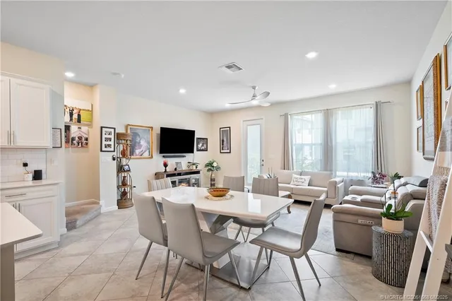 a living room with furniture kitchen view and a flat screen tv