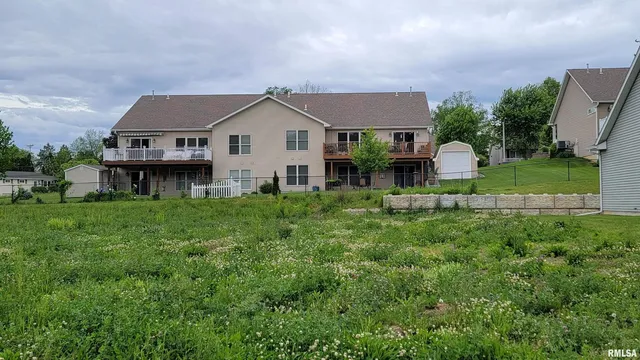 a view of a house with a big yard and large trees