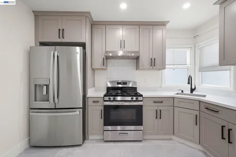 a kitchen with cabinets appliances a sink and a window