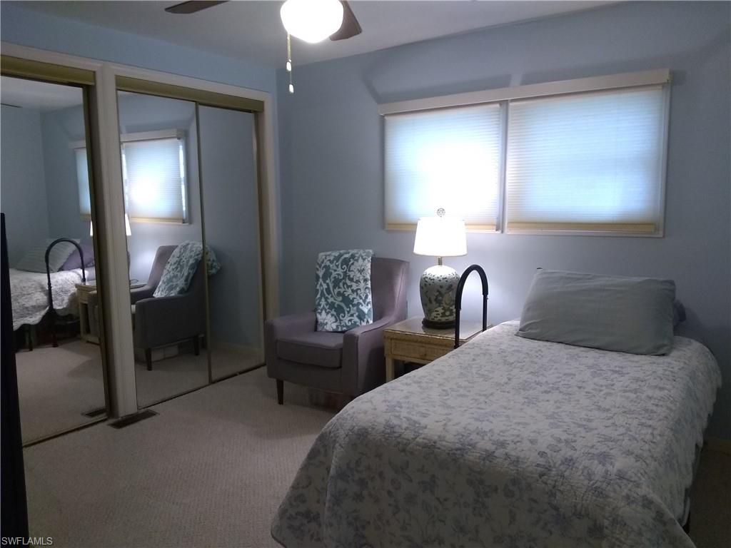 15 Cannes Drive Naples, FL 34112 - Photo 28 of 33 a bedroom with a bed and a mirror on dresser