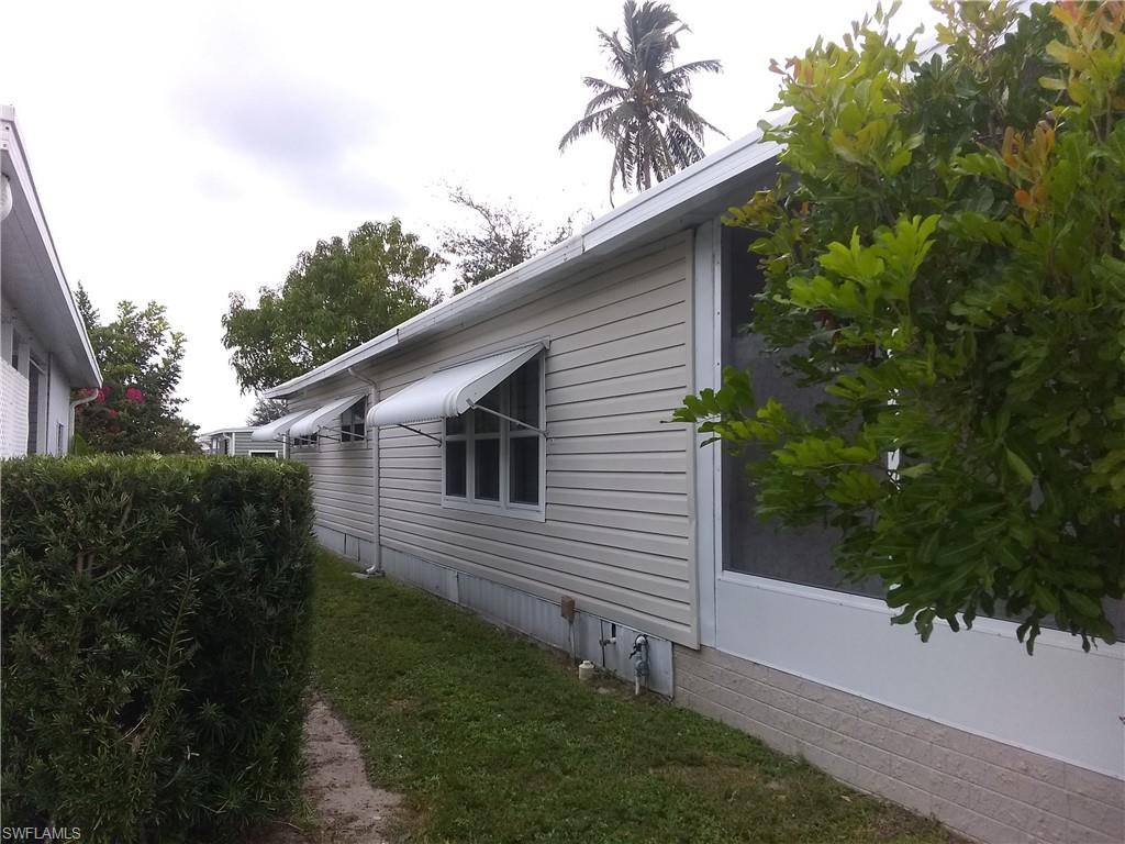 15 Cannes Drive Naples, FL 34112 - Photo 32 of 33 a backyard of a house with plants and palm tree