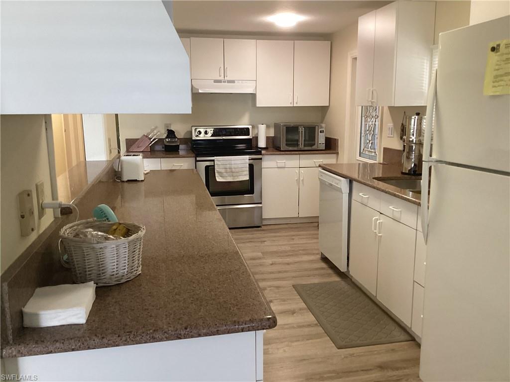 15 Cannes Drive Naples, FL 34112 - Photo 8 of 33 a kitchen with stainless steel appliances granite countertop a sink a stove and a refrigerator