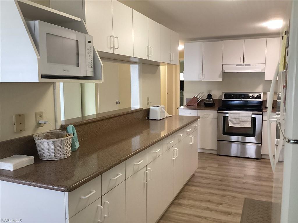 15 Cannes Drive Naples, FL 34112 - Photo 9 of 33 a kitchen with stainless steel appliances granite countertop a sink a stove and cabinets