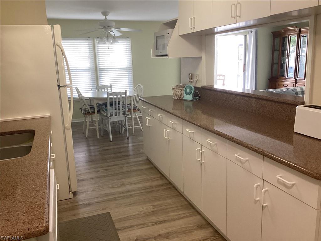 15 Cannes Drive Naples, FL 34112 - Photo 10 of 33 a large kitchen with lots of counter space a sink and dining table chairs