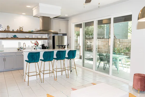 a kitchen with stainless steel appliances kitchen island granite countertop a table and chairs in it