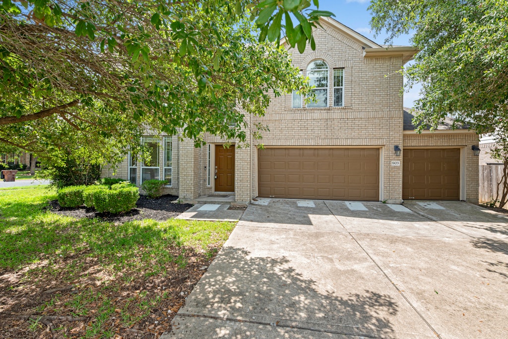 a front view of a house with a yard and garage