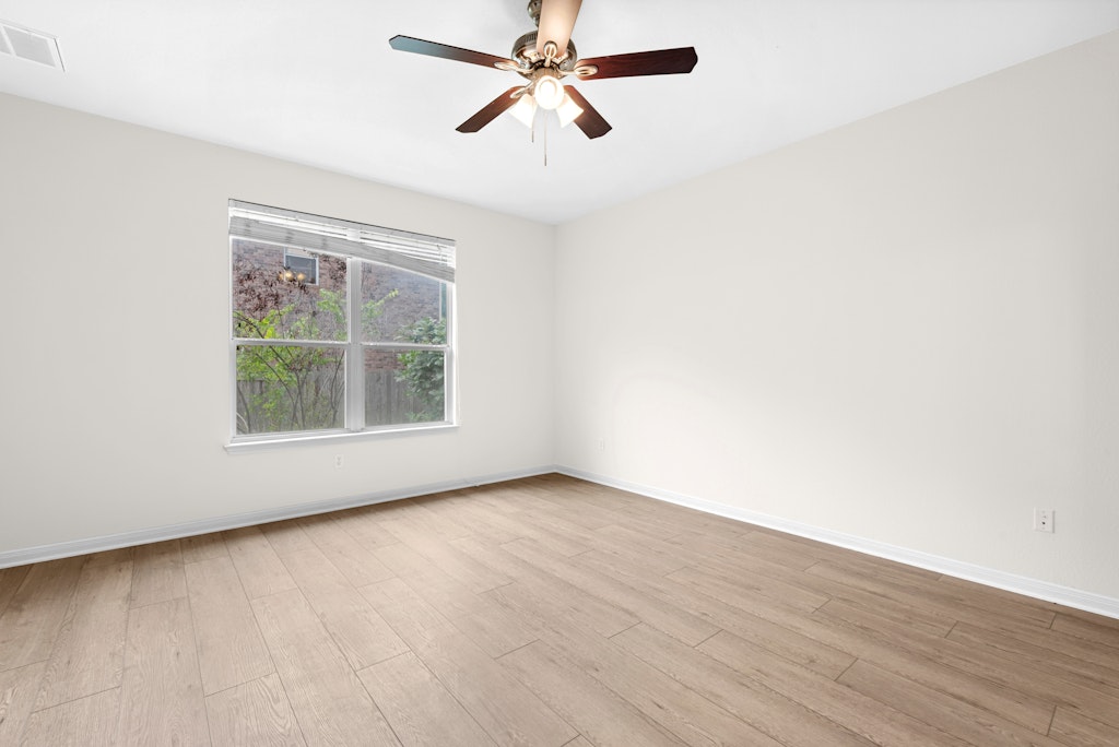 903 Fork Ridge Path Round Rock, TX 78665 - Photo 28 of 35 an empty room with wooden floor chandelier fan and windows