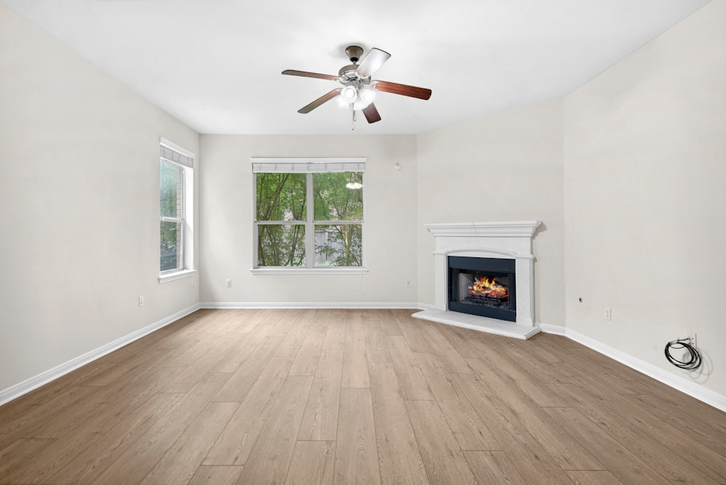903 Fork Ridge Path Round Rock, TX 78665 - Photo 7 of 35 an empty room with windows fireplace and wooden floor