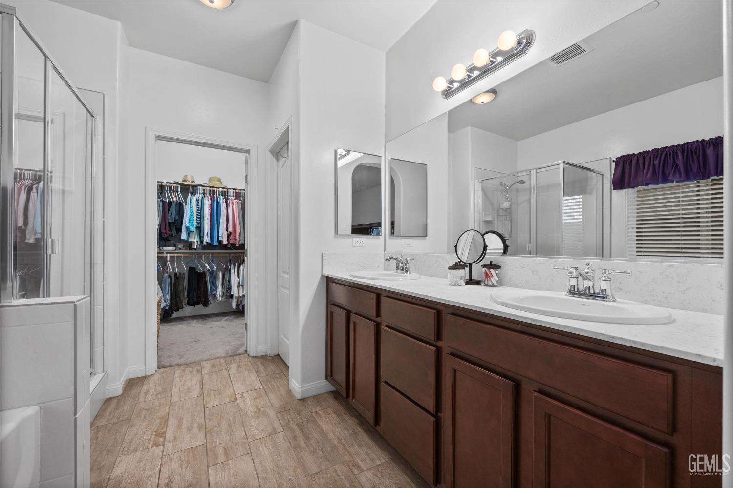 Undisclosed Address Bakersfield, CA 93313 - Photo 12 of 24 a spacious bathroom with a double vanity sink and a mirror