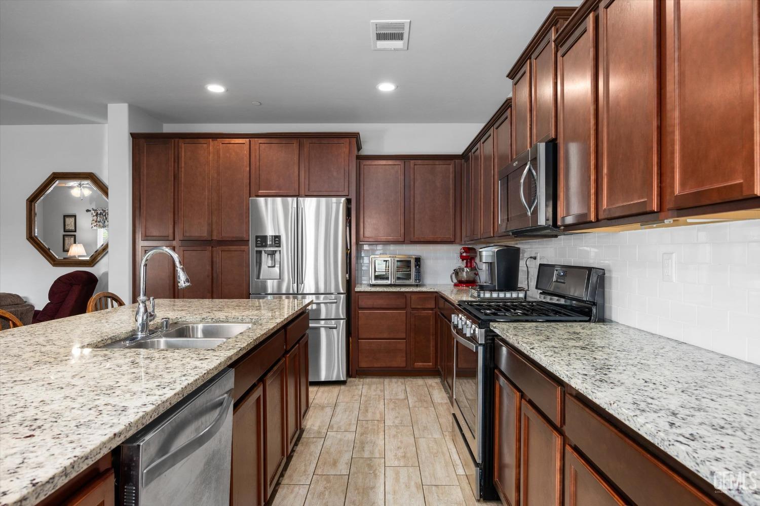 Undisclosed Address Bakersfield, CA 93313 - Photo 9 of 24 a kitchen with granite countertop stainless steel appliances a stove top oven a sink and dishwasher