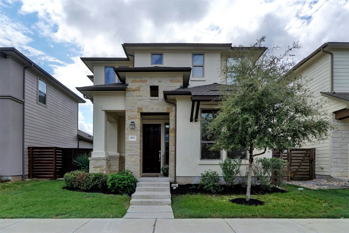 a front view of a house with a garden
