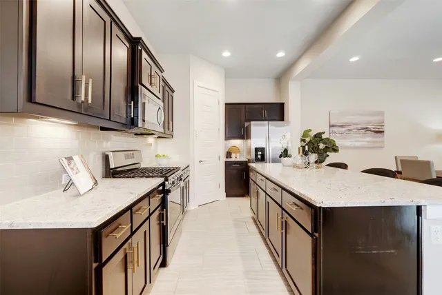 a kitchen with stainless steel appliances granite countertop a sink stove top oven and refrigerator