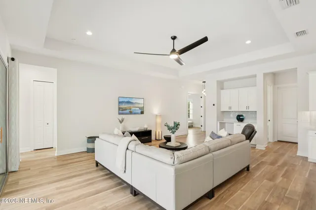 a kitchen with stainless steel appliances kitchen island granite countertop a table chairs and a view of living room